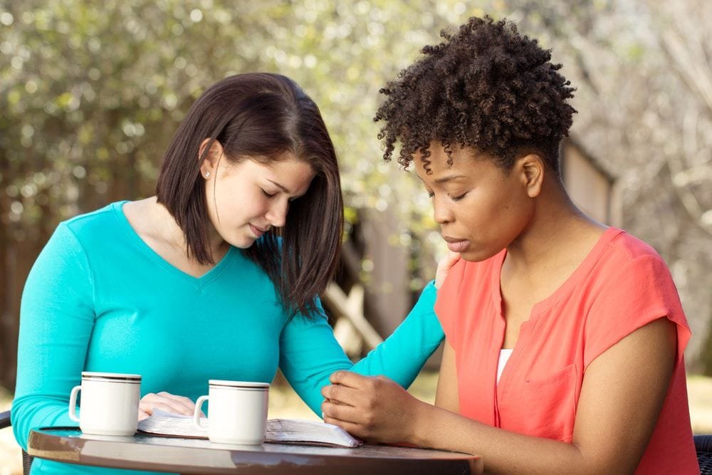 Two women praying together