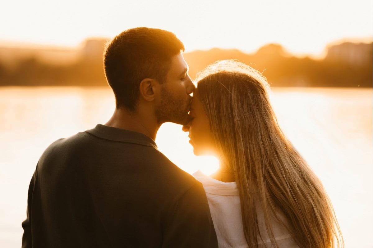 a couple embrace while bathed in sunlight.
