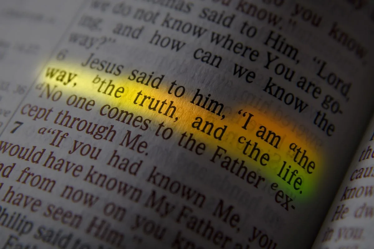 A Bible with the verse "I am the way, the truth, and the life" highlighted.