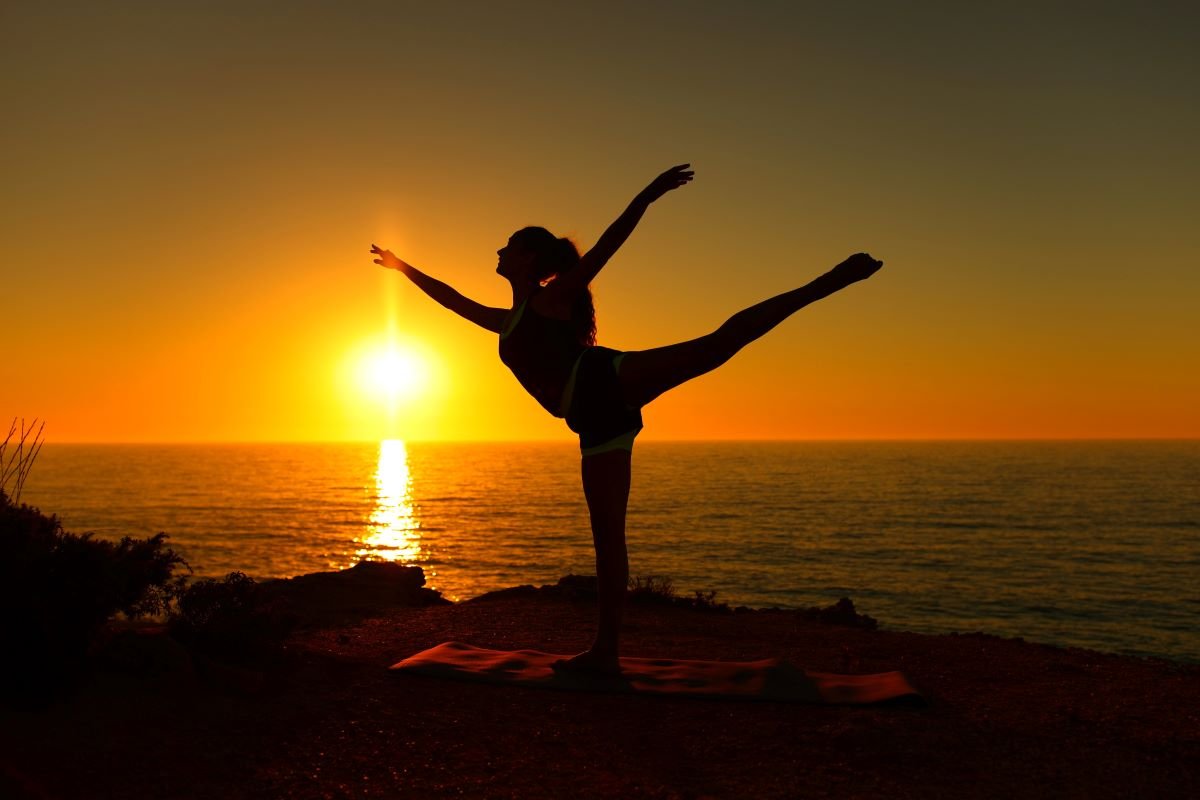 Ballerina on the beach at sunset posing.