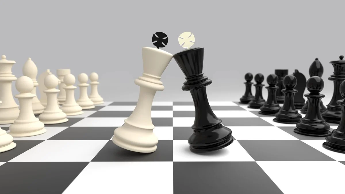 Black and white chess pieces facing off on chessboard.